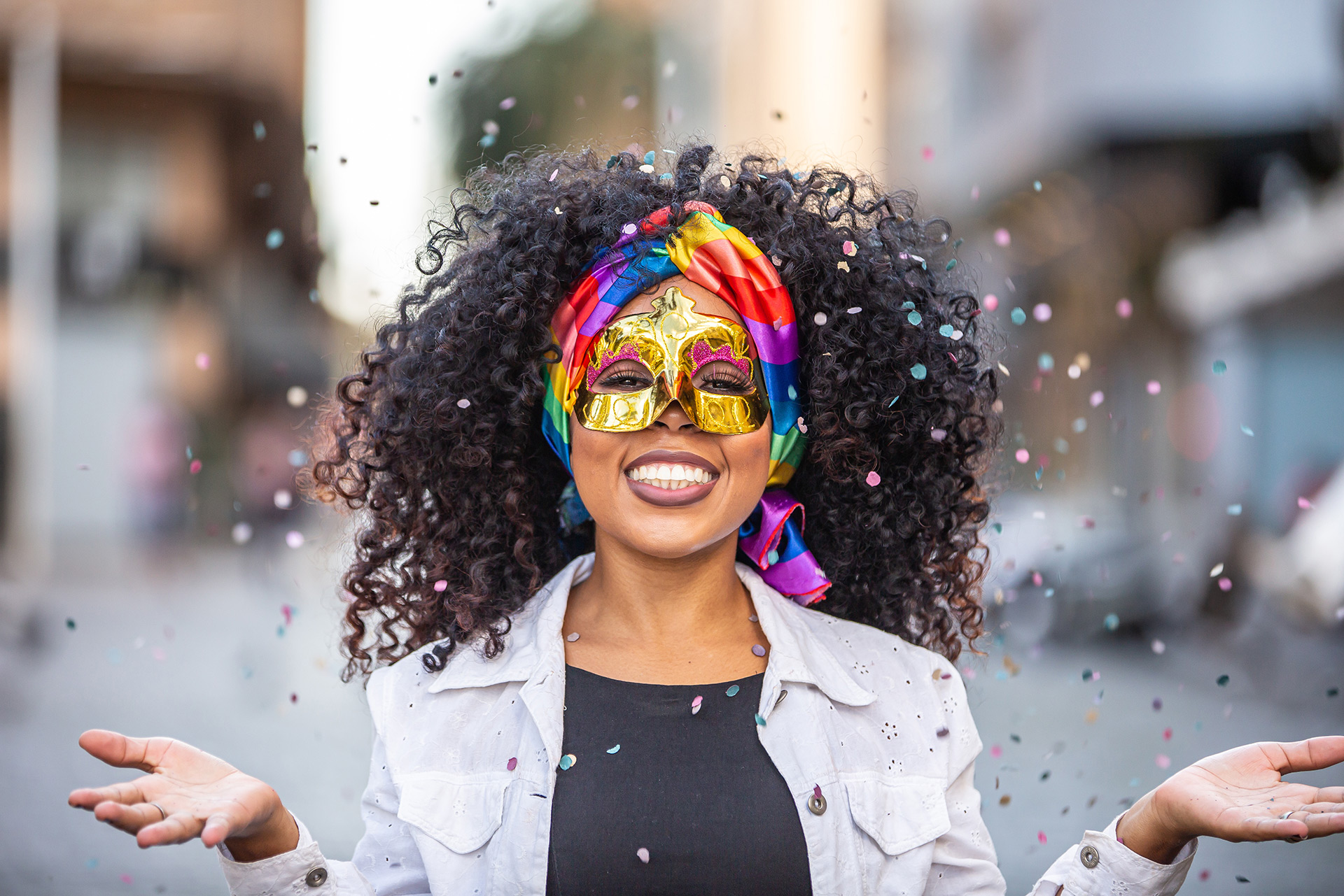 Happy LGBTQ ally wearing a mask and throwing glitter