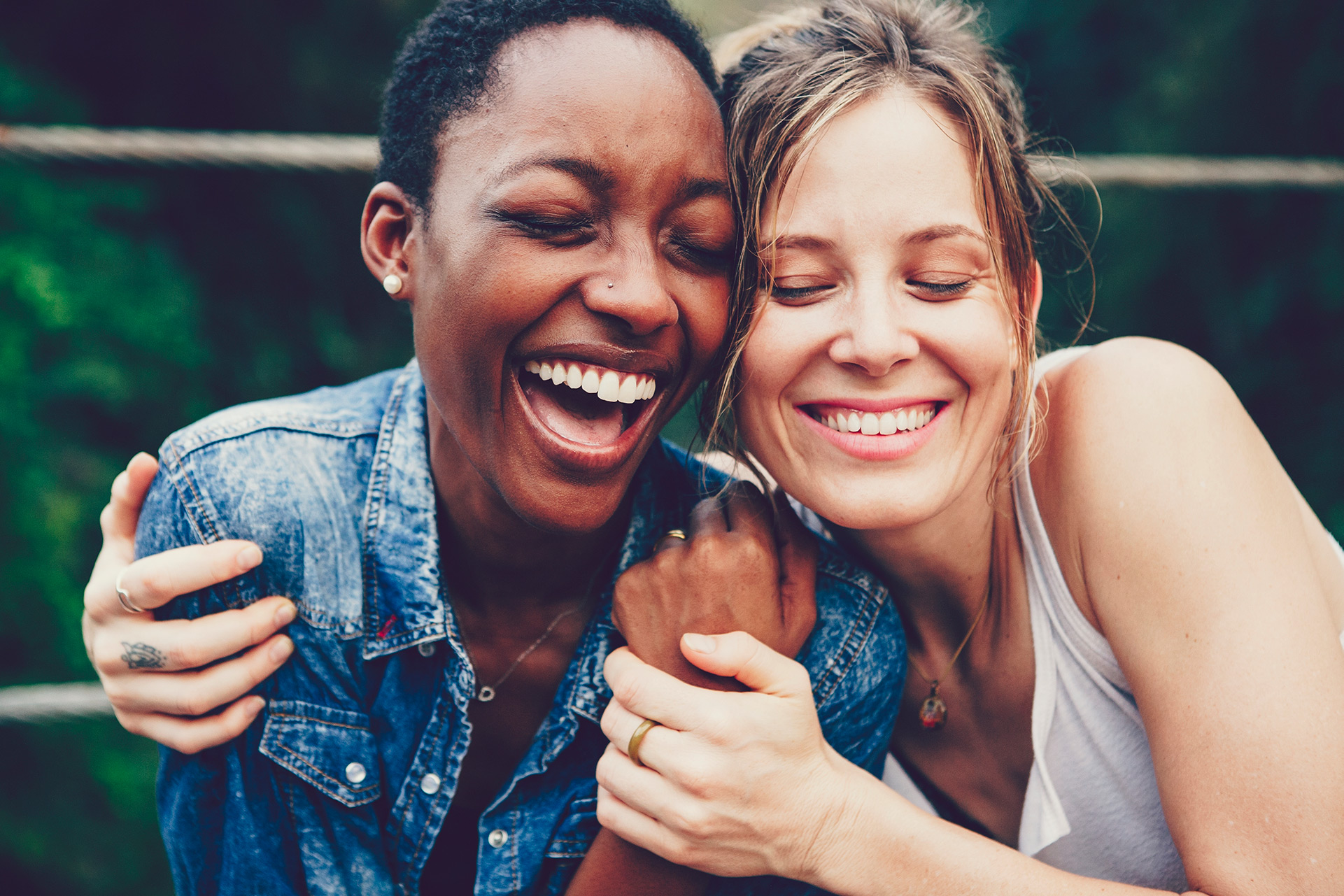 Smiling duo hugging with eyes closed